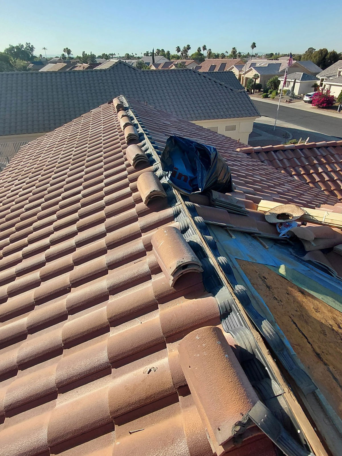 Tile roof repair in Sun City West AZ showing ridge area repairs during underlayment replacement and tile reset process