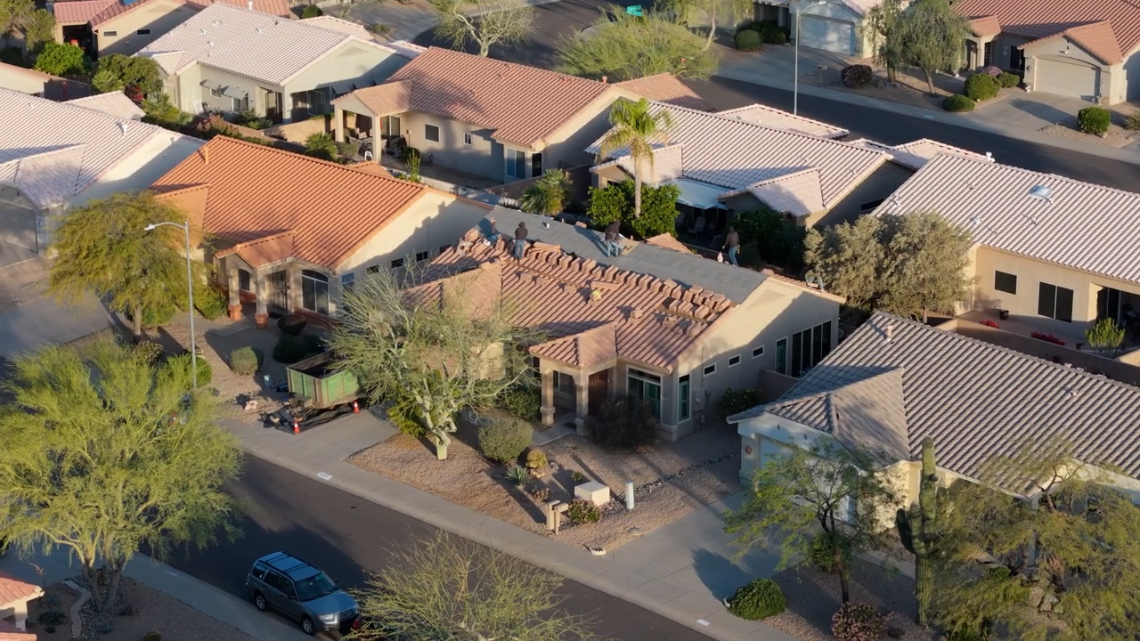 Tile roof tile removal process in Sun City Arizona showing crew removing existing roof tiles